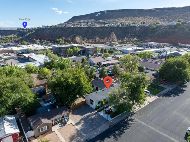 Overhead perspective of a residential property with surrounding neighborhood and distant hillside