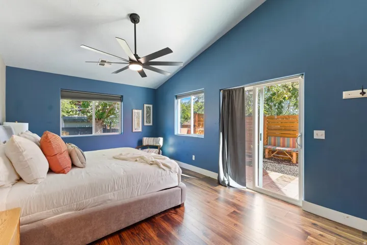 Wood-finish flooring, vaulted ceiling, and a modern ceiling fan
