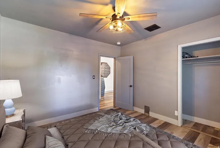 Wood-finish flooring throughout, ceiling fan with integrated lighting, recessed lighting, and a built-in closet with shelving and hanging rod