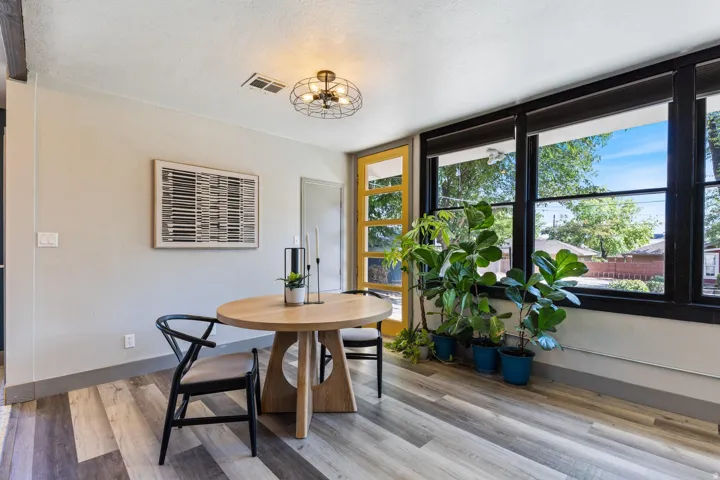 Wood-finish flooring, black window trim, and a decorative ceiling fixture