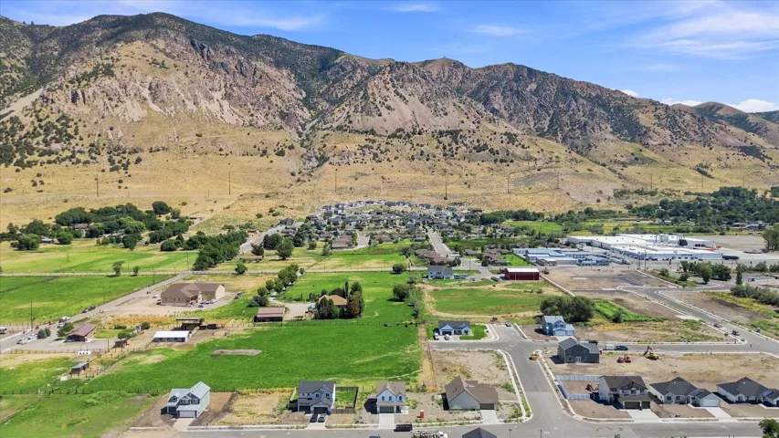 Mountainous backdrop, residential development, expansive undeveloped land, established agricultural areas, commercial structures