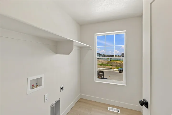 Built-in wall shelving, wood-finish flooring, and a window with grid detailing
