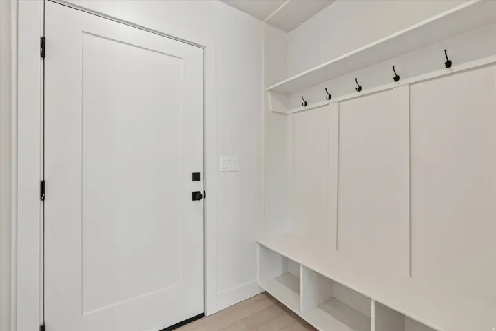 Built-in mudroom bench with storage cubbies and upper shelving