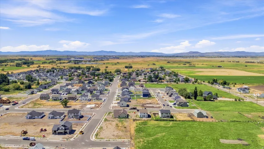 Newly developed residential area with established infrastructure, surrounded by expansive agricultural fields