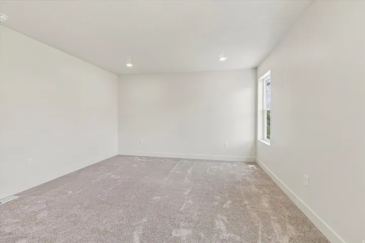 Recessed lighting, light-toned walls, and carpet flooring