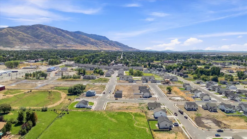 Expansive community with mountain backdrop, established street grid, and a mix of completed homes and developable land