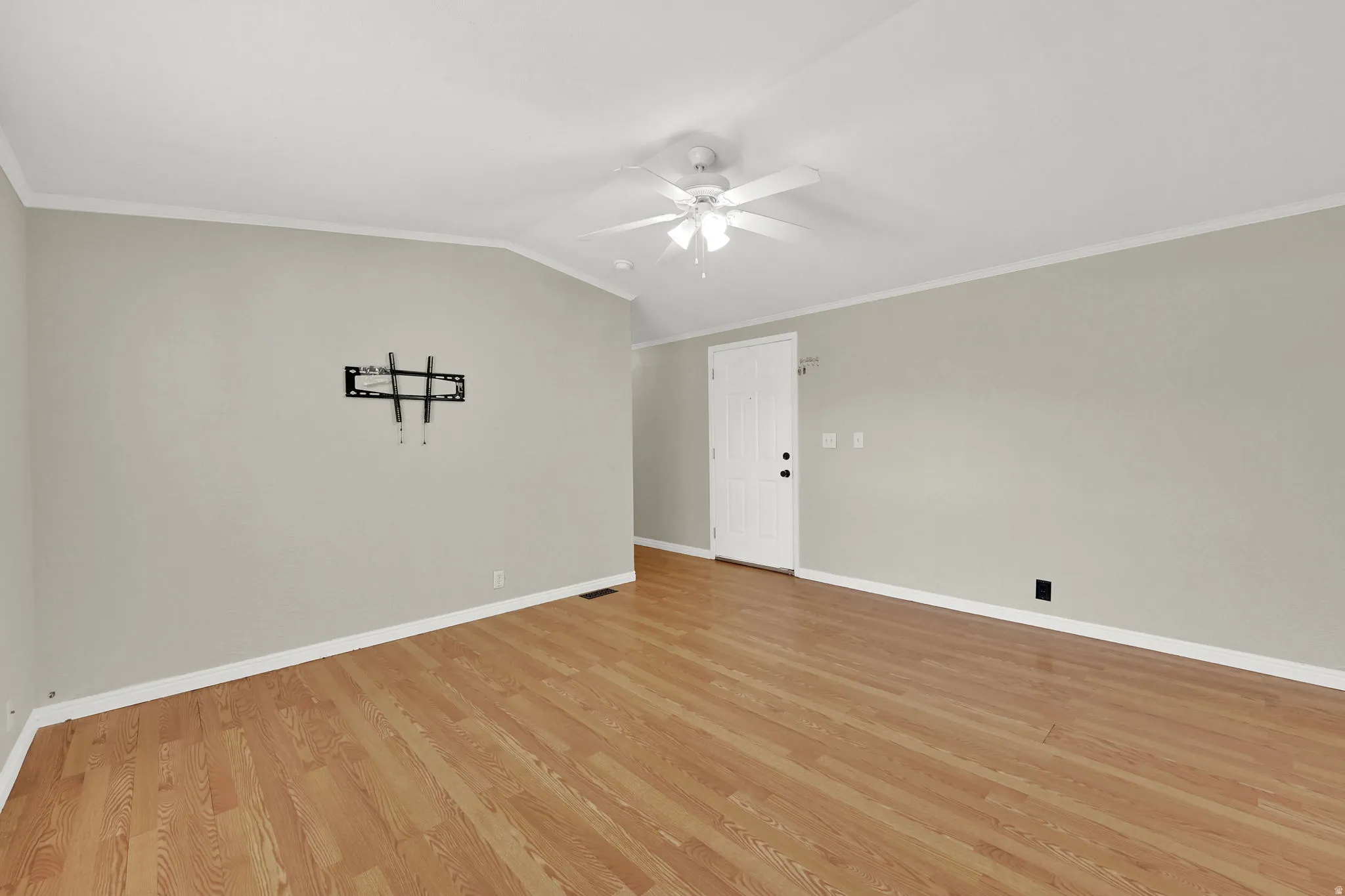 Spacious interior featuring wood-finish flooring, vaulted ceiling, and ceiling fan