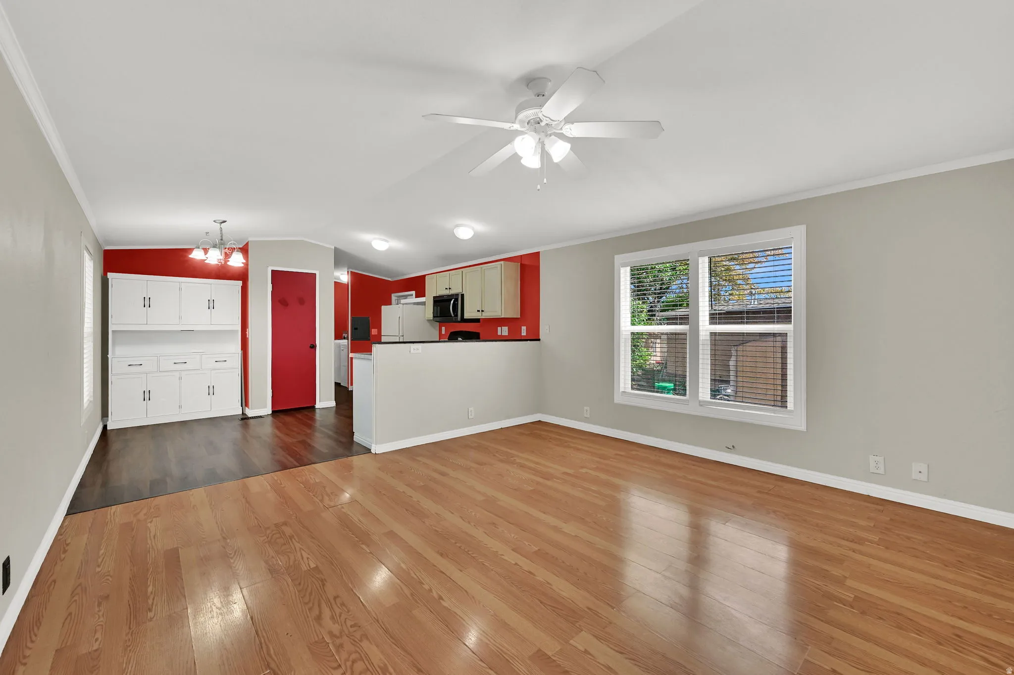 Hardwood flooring, ceiling fan, window with blinds, built-in cabinetry, and white appliances