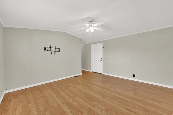 Spacious interior featuring wood-finish flooring, vaulted ceiling, and ceiling fan