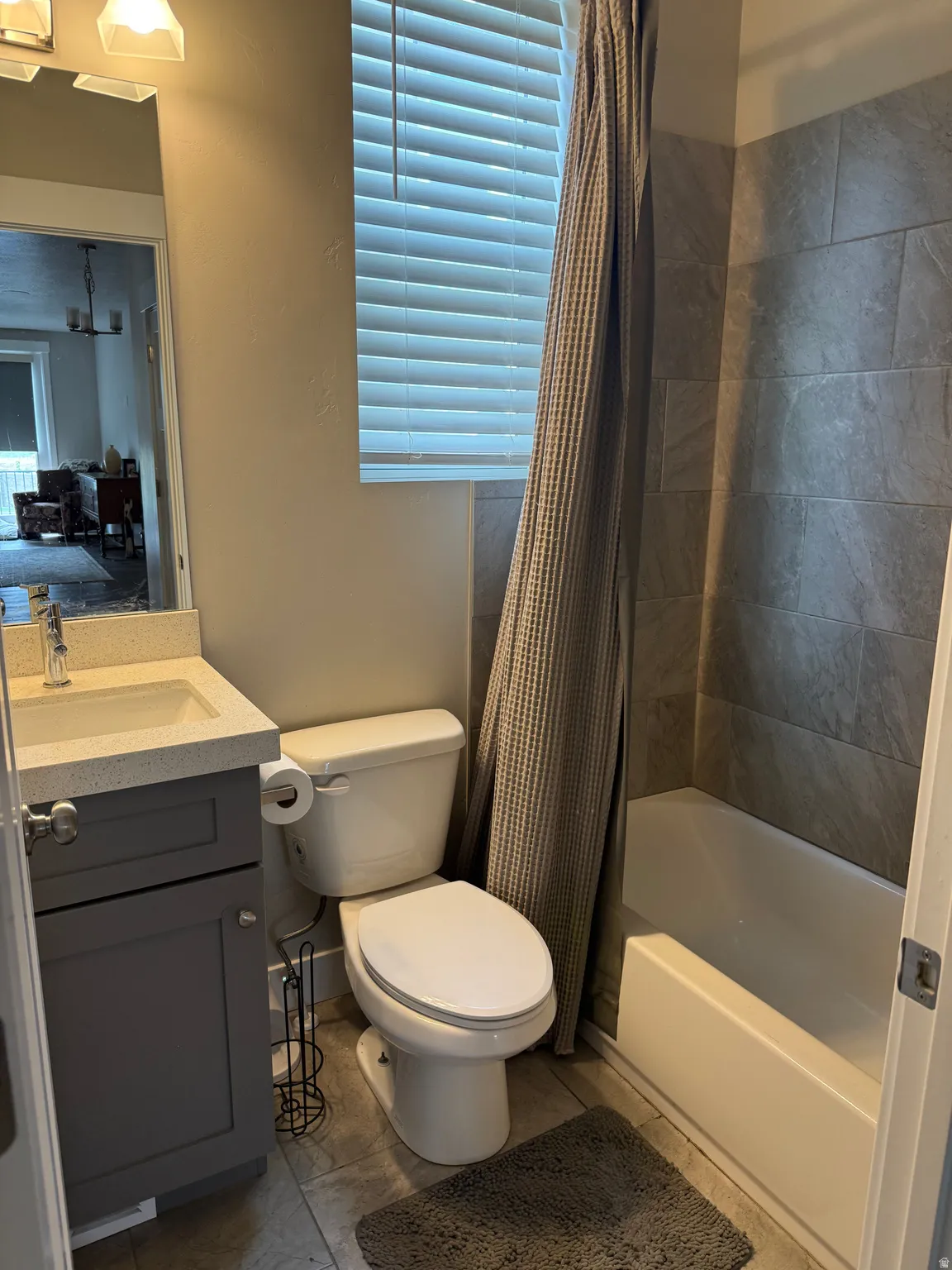 Bathroom with a vanity featuring a light-colored countertop, a built-in sink, and gray cabinetry