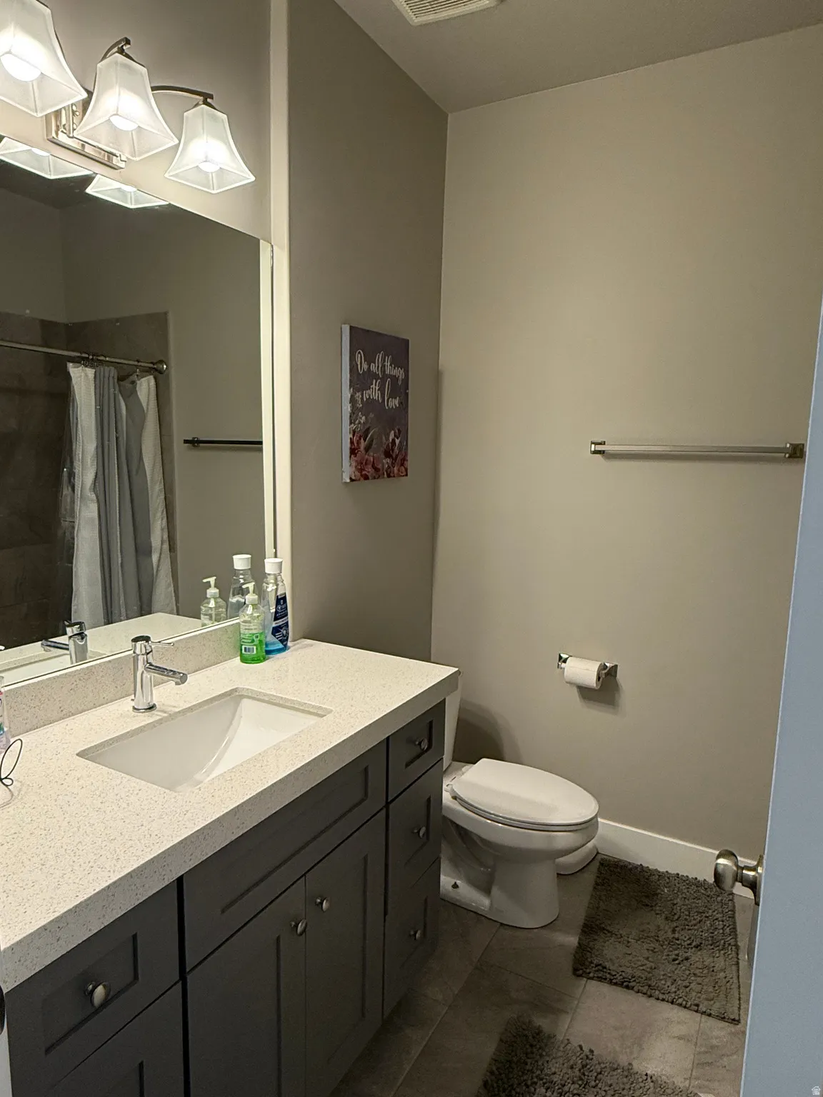 Vanity with stone-finish countertop, integrated sink, and brushed nickel faucet