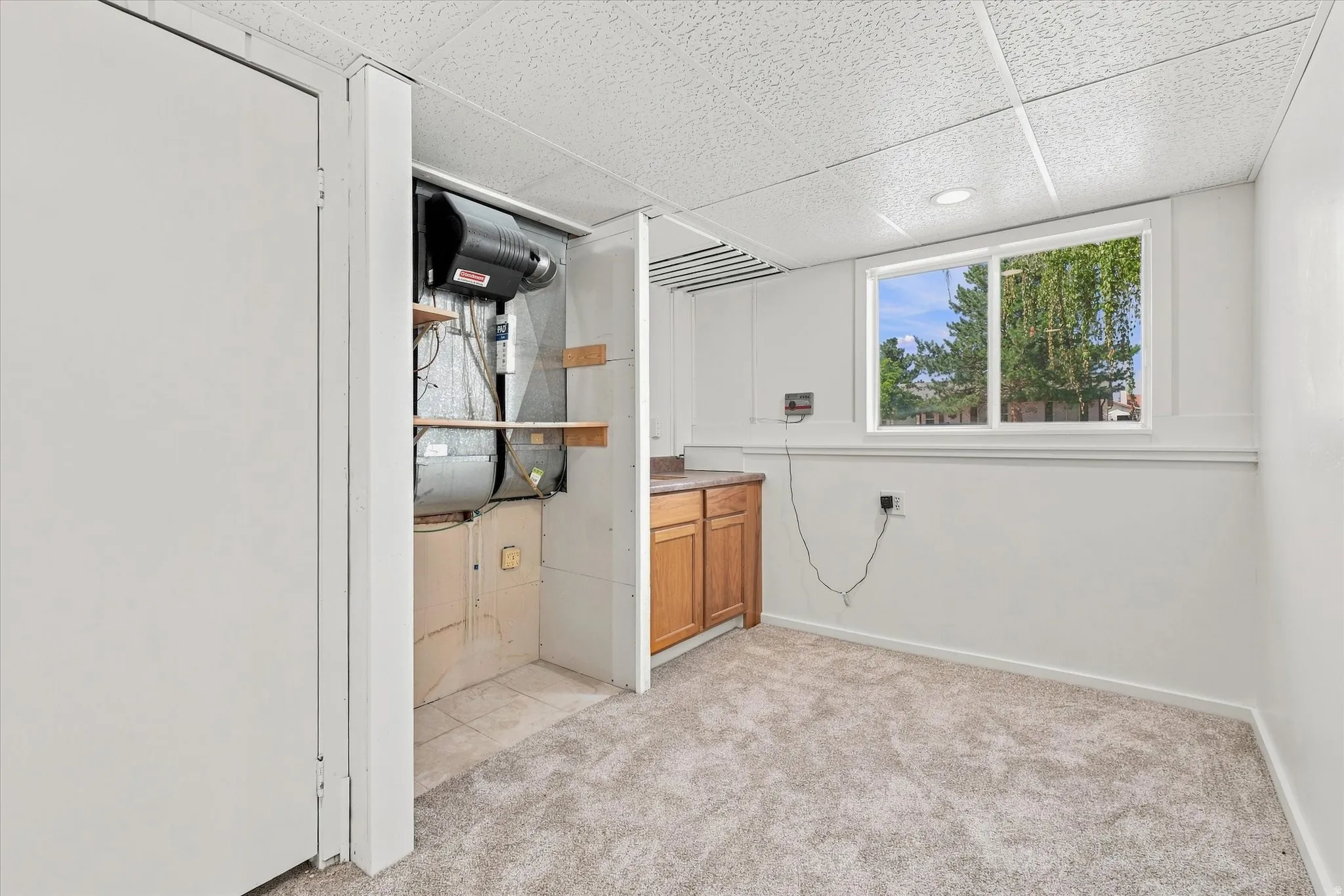 Recessed lighting, wood-finish cabinetry, built-in HVAC system, window, and carpeted flooring
