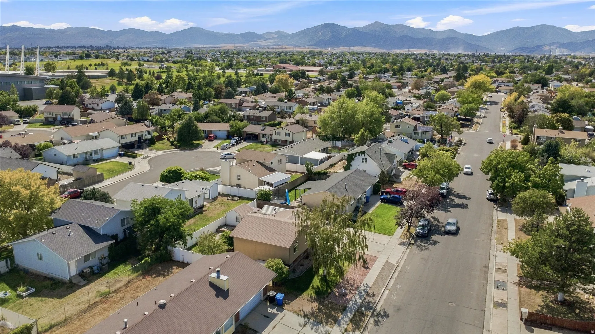 Residential neighborhood with tree-lined streets and mountain backdrop