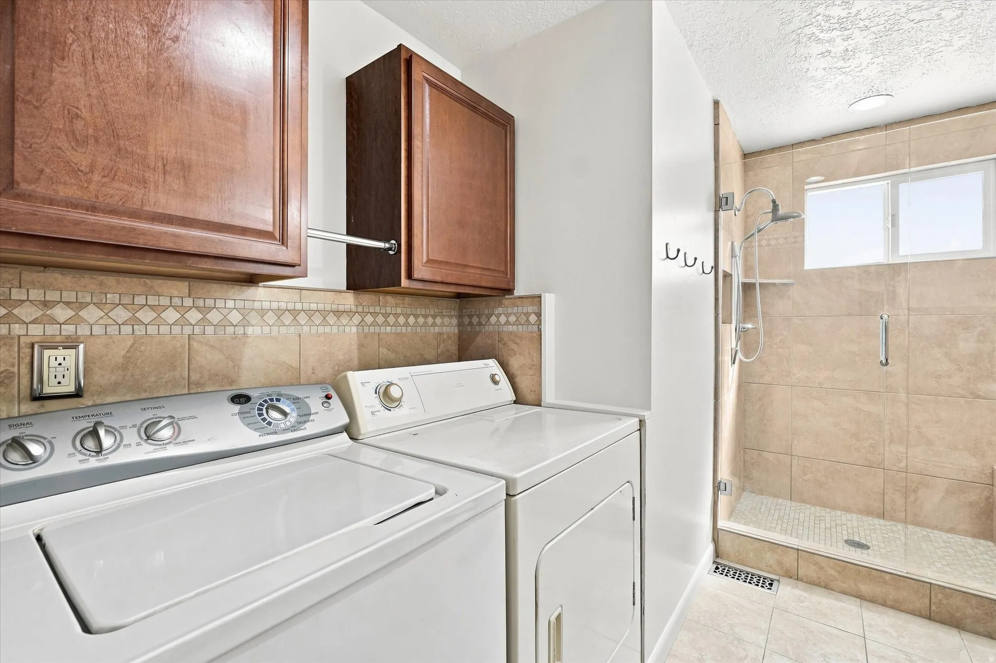 Tiled shower enclosure with glass door, dual windows, and a built-in shelf