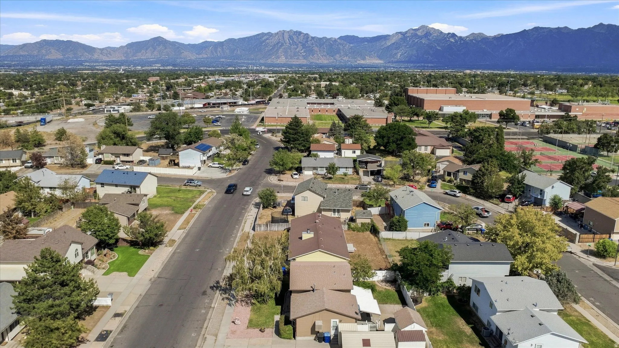 Neighborhood with mature trees and mountain backdrop