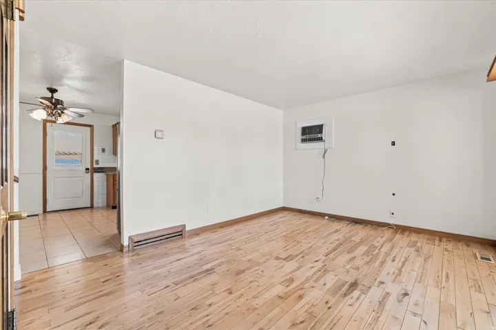 Wood-finish flooring throughout the main room, with a window-mounted air conditioning unit