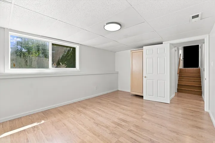 Wood-finish flooring, drop ceiling, and a flush-mount ceiling light