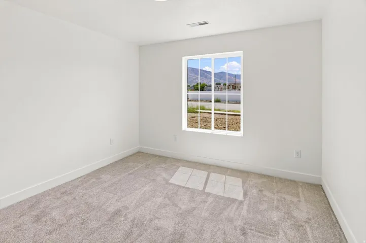 Carpeted flooring, white walls, white trim, and a multi-pane window