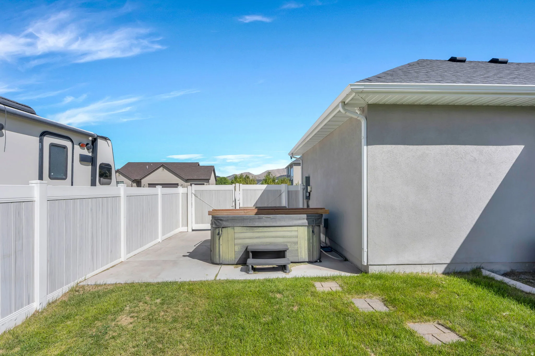 Private backyard area featuring a hot tub, concrete patio, and a privacy fence