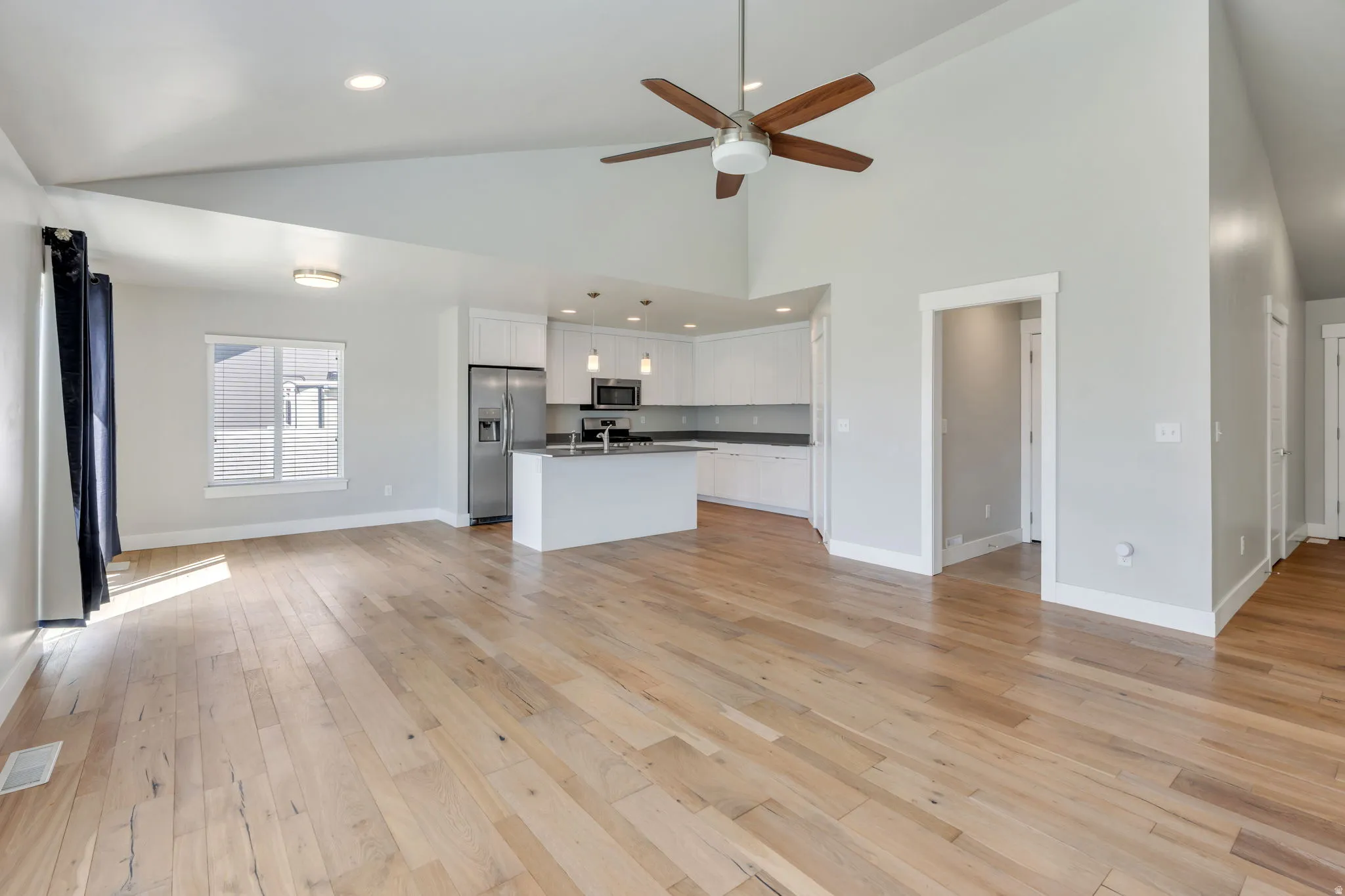 Varnished wood-finish flooring, vaulted ceilings, and recessed lighting