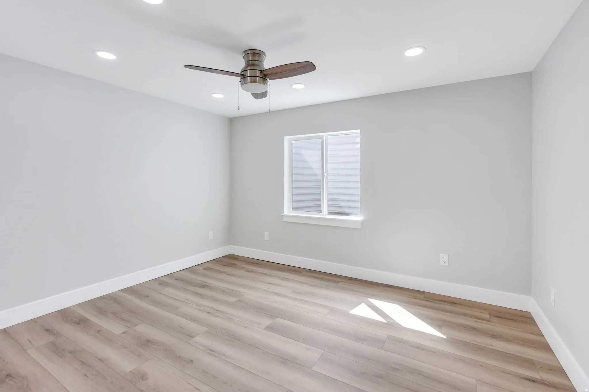 Wood-finish flooring, recessed lighting, ceiling fan, and a window with blinds