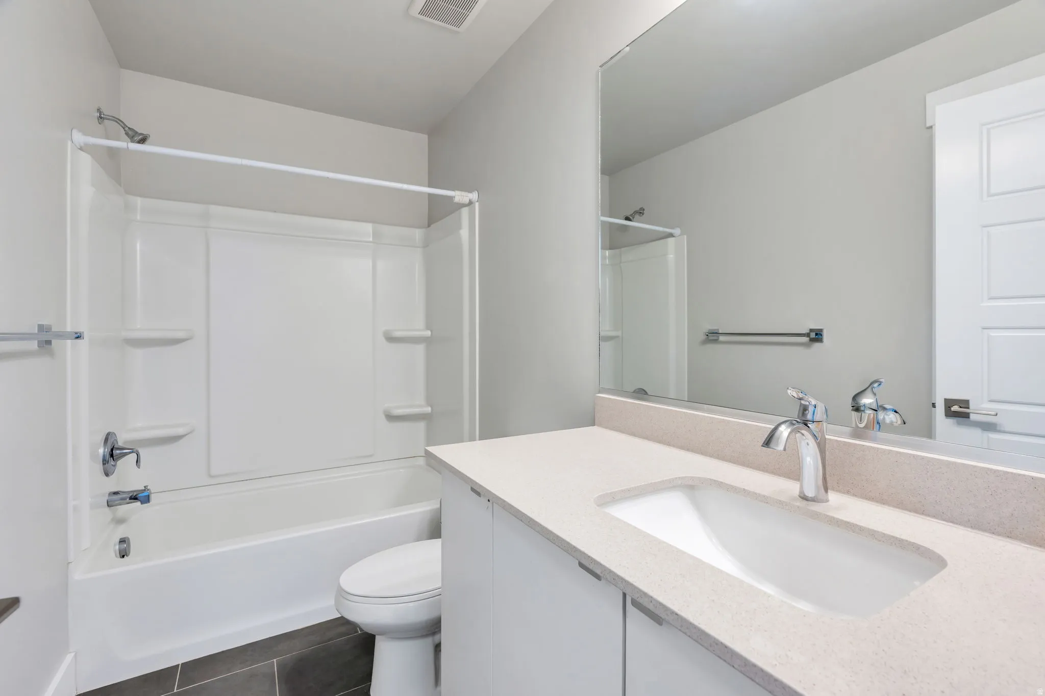 White vanity with an integrated rectangular sink, chrome fixtures, and a large wall-mounted mirror