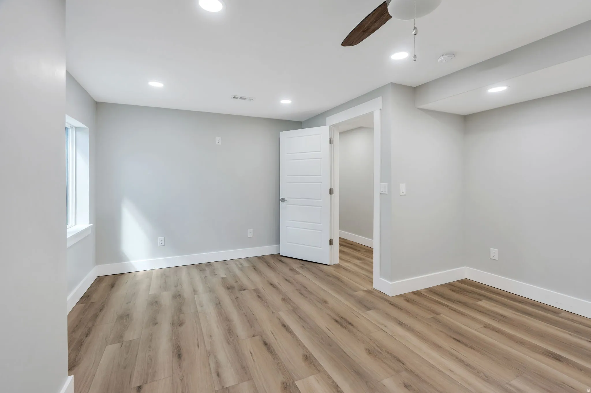 Room with wood-finish flooring, recessed lighting, a ceiling fan, and white trim