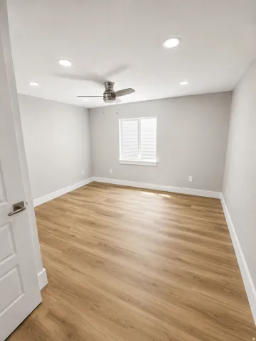 Recessed lighting, wood-finish flooring, and a ceiling fan with brushed nickel hardware