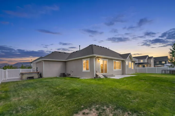Spacious backyard with a manicured lawn, an expansive concrete patio, and a privacy fence