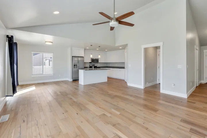Varnished wood-finish flooring, vaulted ceilings, and recessed lighting