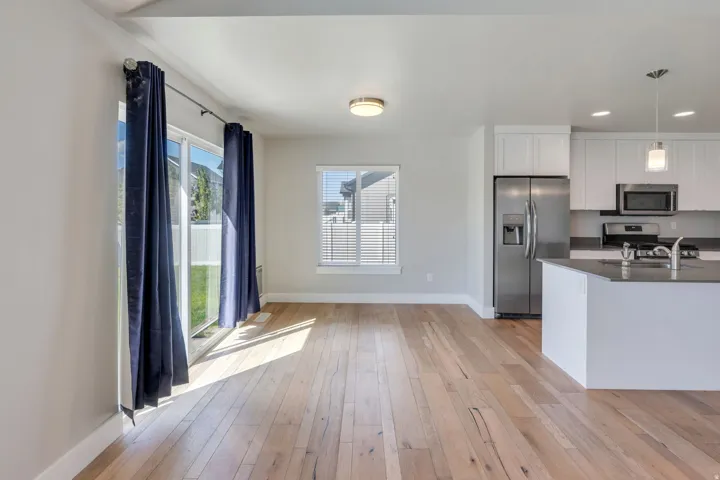 Open-concept living space featuring wood-finish flooring, a sliding glass door, and recessed lighting