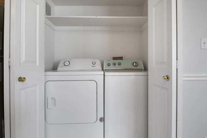 Laundry closet featuring bifold doors and built-in shelving