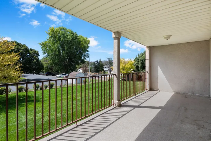 Covered balcony with a painted concrete floor and a metal railing