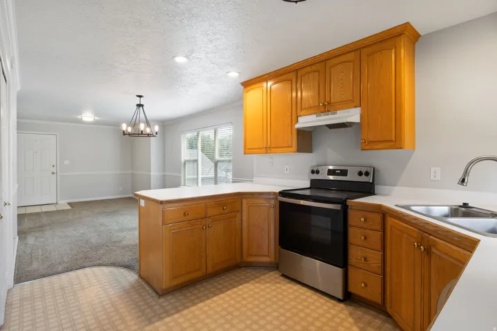 Kitchen featuring wood cabinetry, stainless steel range, and a double basin sink