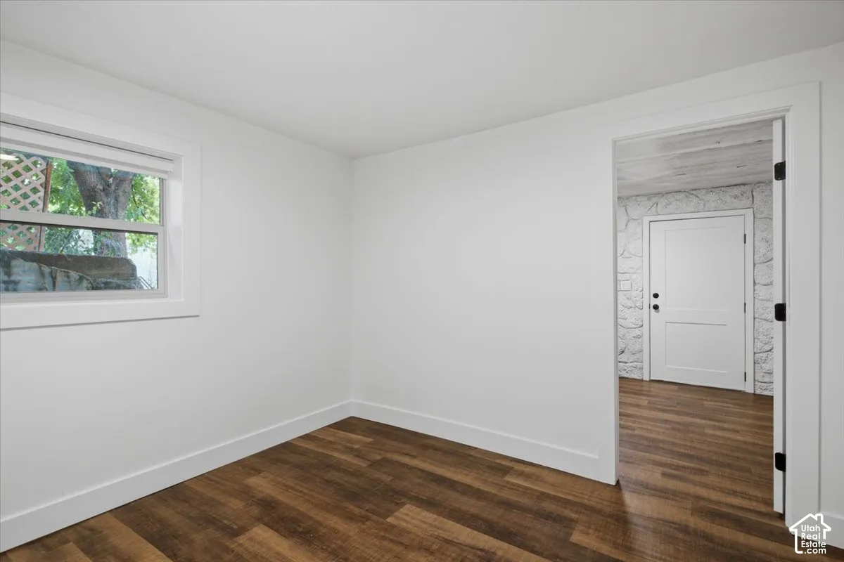Wood-finish flooring, white walls, and a white window frame with a lattice pattern
