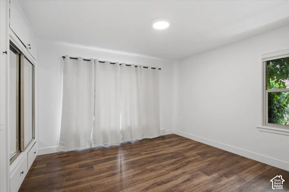 Recessed ceiling light, wood-finish flooring, built-in cabinetry with mirrored doors, window with exterior foliage