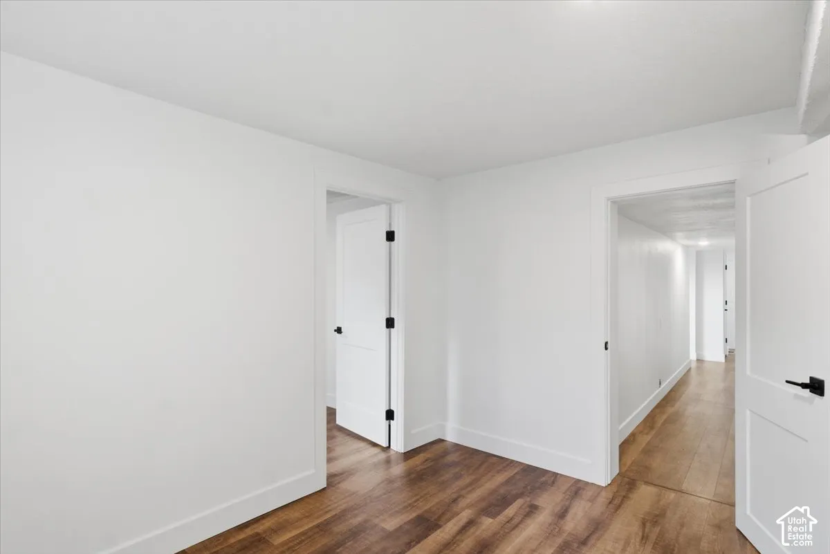 Wood-finish flooring, white walls, white interior doors, and matte black door hardware