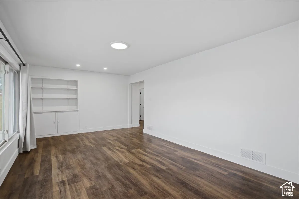 Wood-finish flooring, recessed lighting, built-in shelving, and large windows
