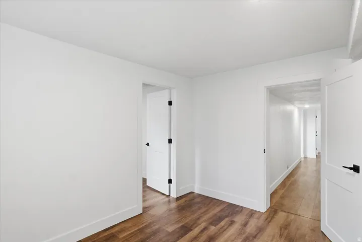 Wood-finish flooring, white walls, white interior doors, and matte black door hardware