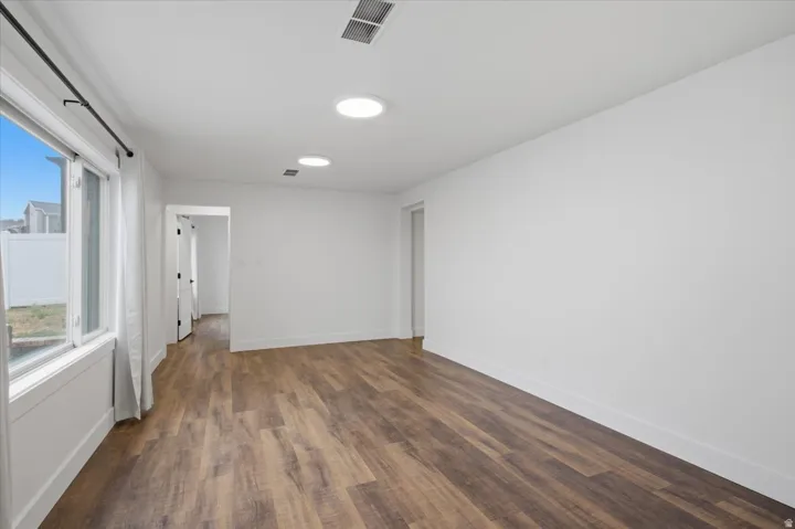 Recessed lighting, wood-finish flooring, white walls, and white trim