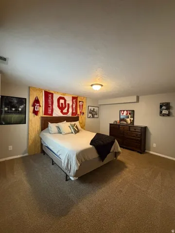 Spacious bedroom with carpeted flooring, recessed ceiling lighting, and ample square footage