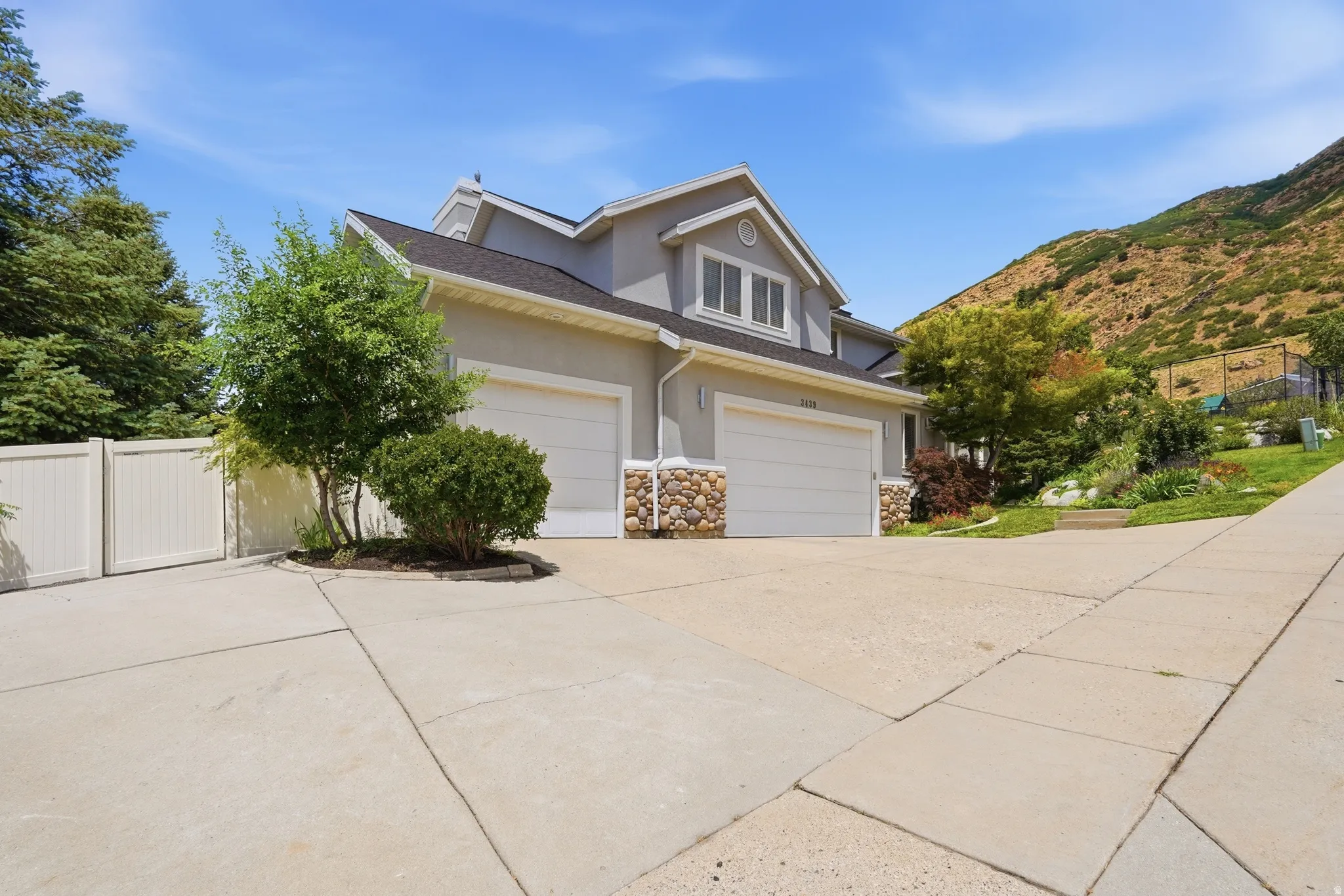 Two-car garage with white doors, stone accents, and stucco exterior