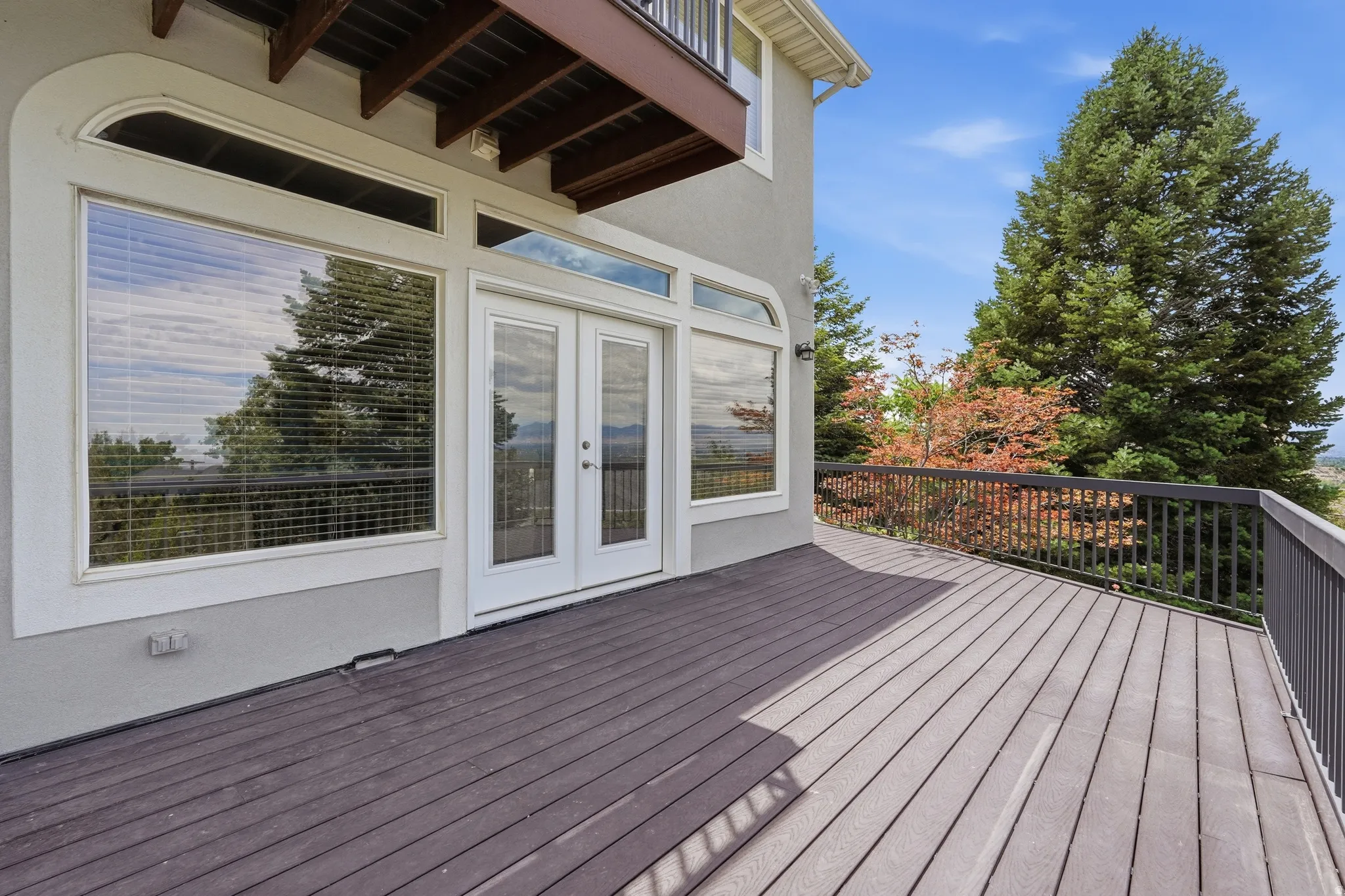 Expansive exterior deck with wood-finish decking and dark metal railings
