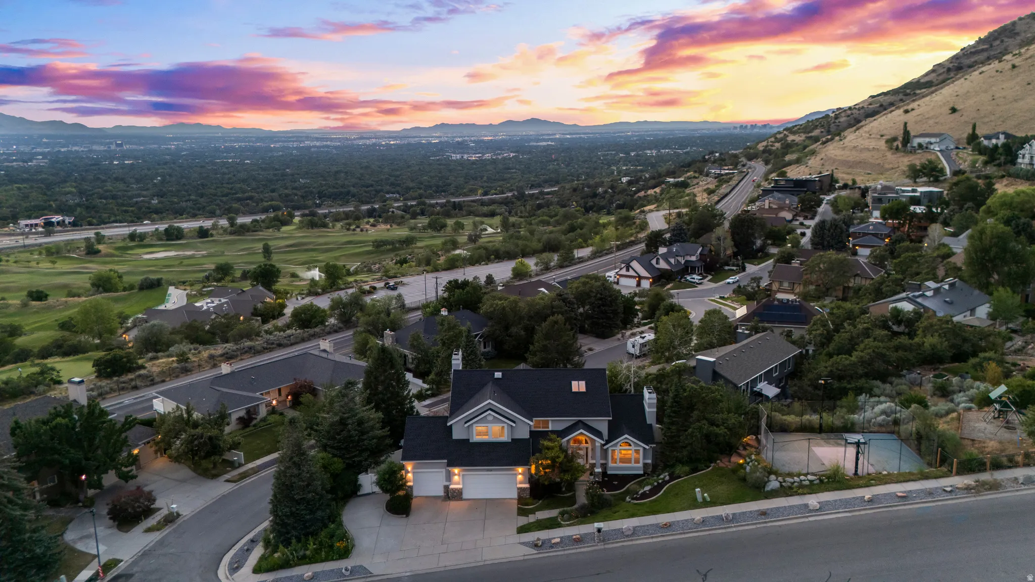 Residential property featuring a multi-car garage, mature landscaping, and a paved driveway