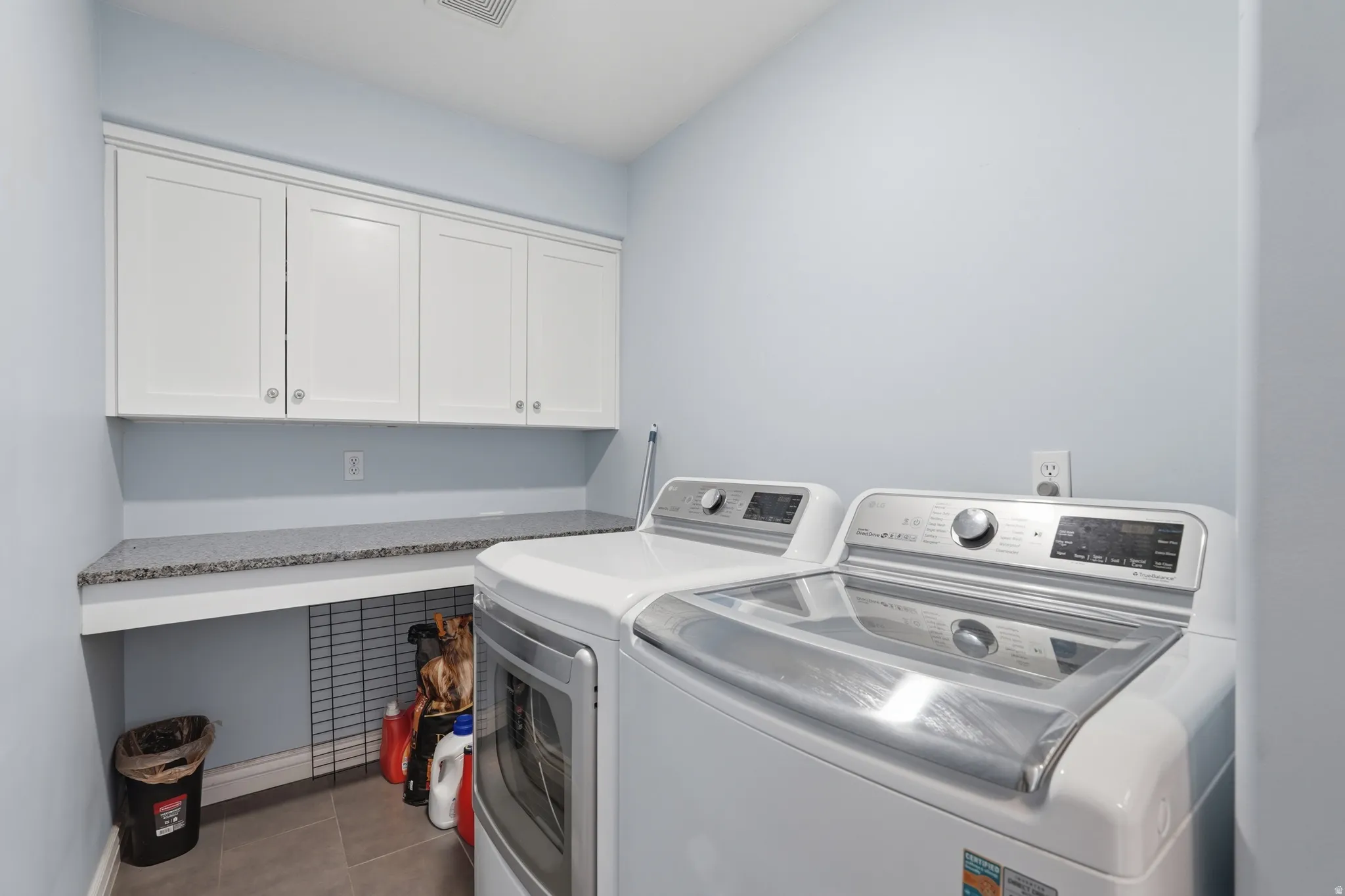 White shaker cabinetry with chrome hardware, extensive countertop space, and light gray wall paint