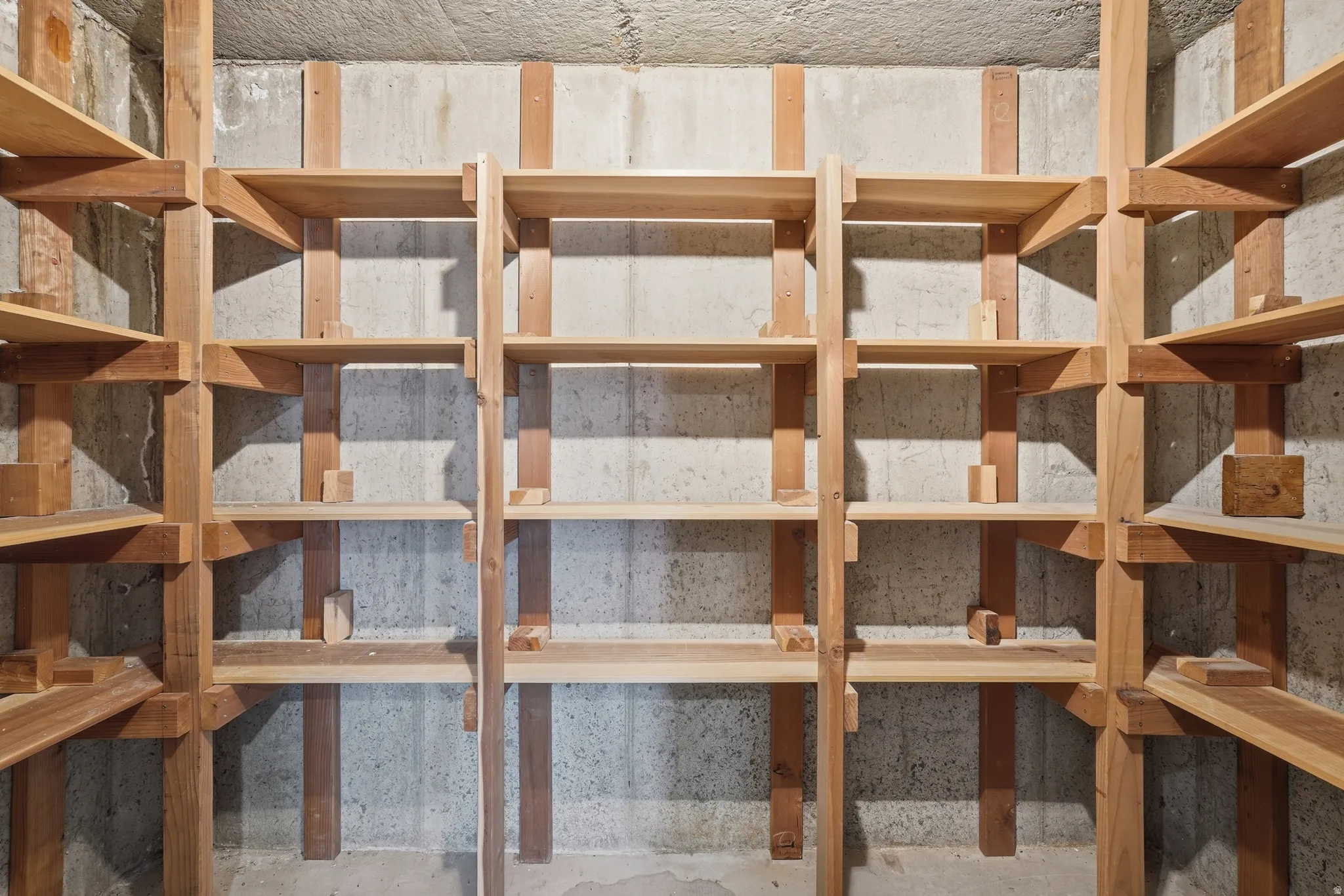 Built-in wood shelving against a concrete wall