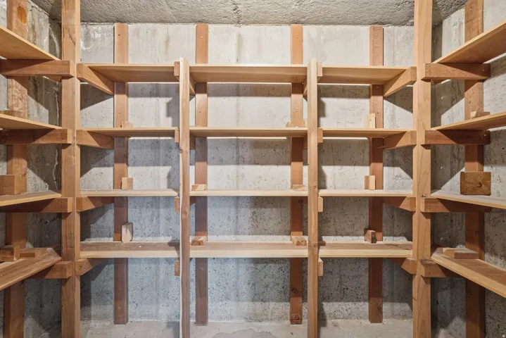 Built-in wood shelving against a concrete wall