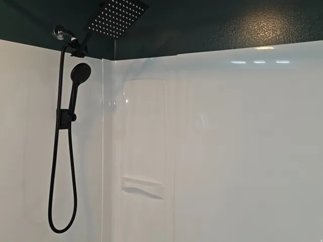 White shower surround with a matte black dual shower head system