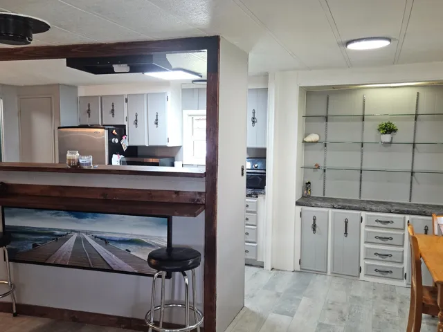 Built-in breakfast bar with wood-finish framing, wood-finish flooring, and recessed lighting