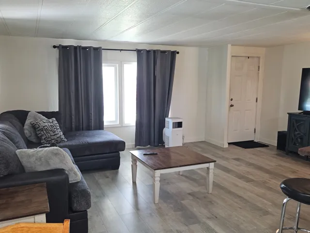 Light wood-finish flooring throughout, white painted walls, and white window trim